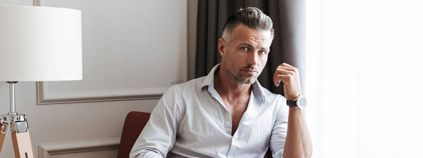 Man sitting by a lamp in white shirt